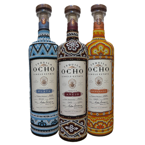 Three bottles of Tequila Ocho Huichol Art Edition with decorative labels on a white background